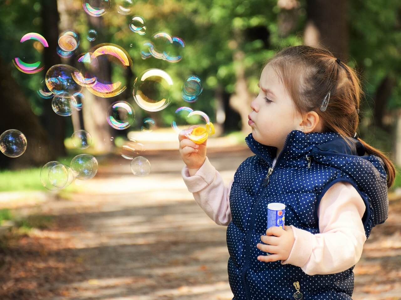 menina fazendo bolhas de sabão