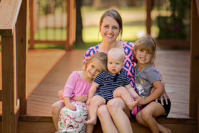 mãe e suas três filhas sorrindo e posando para foto