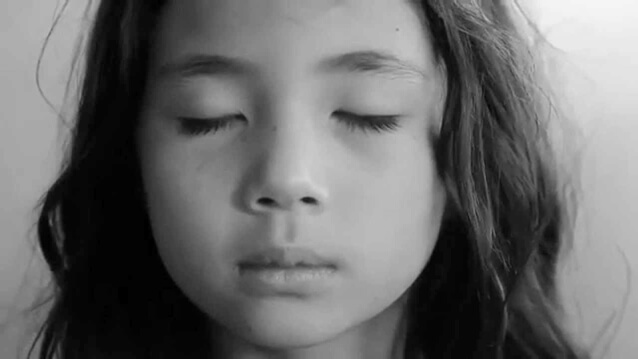 menina de olhos fechados respirando profundamente