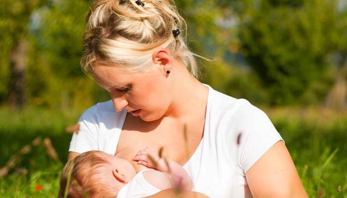 mãe amamentando seu bebê pois a amamentação poderia evitar câncer de mama
