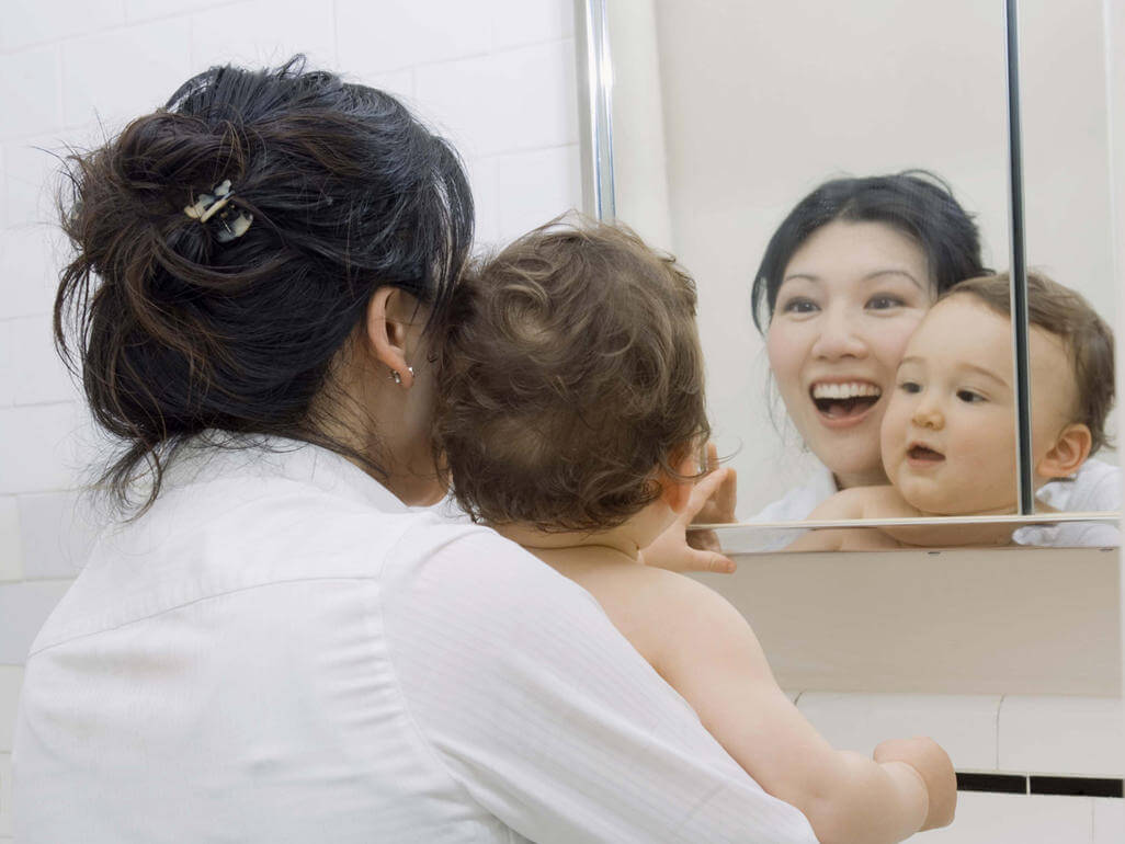 brincar com o bebê em frente ao espelho