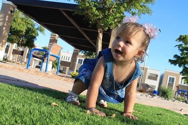 bebê de quatro no chão engatinhando; conquista do primeiro ano