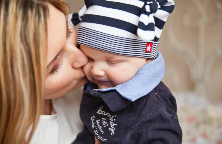mãe beijando seu filho no rosto