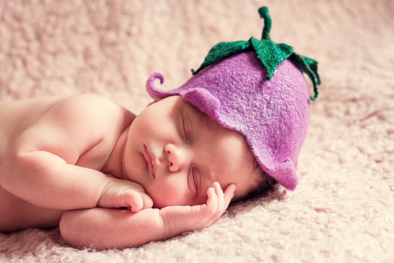 recém-nascido dormindo com uma flor na cabeça