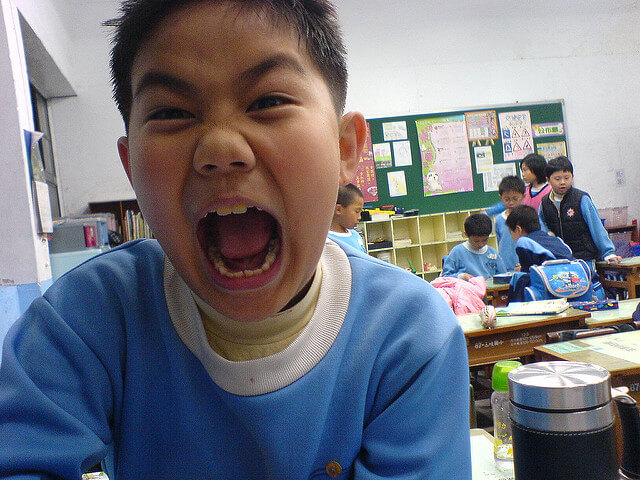 menino gritando irritado na escola