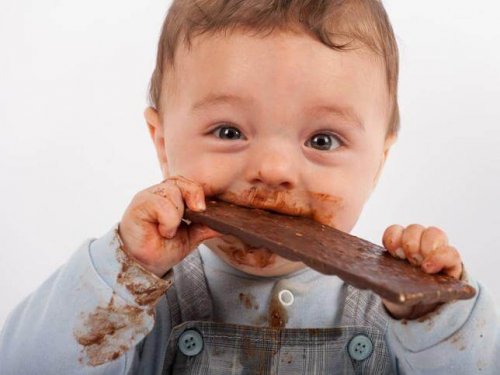 Bebê comendo uma barra de chocolate