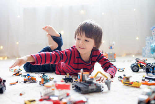 menino brincando com muitos brinquedos