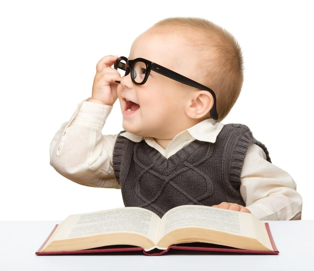 menino usando óculos e com um livro na mão