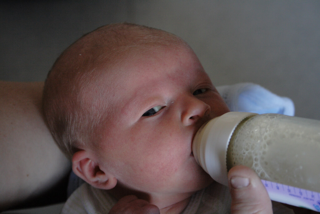 bebê sendo alimentado na mamadeira pelo método Kassing