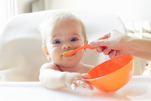 bebê sendo alimentado com alimentos sólidos