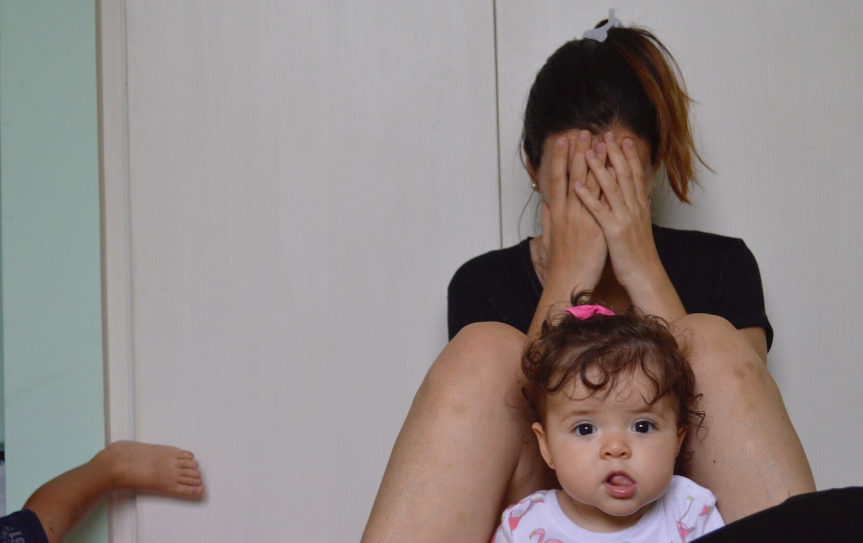 mãe sofredora chorando perto de seus filhos