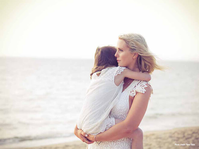 Mãe com a filha na praia desfrutando um momento de pausa