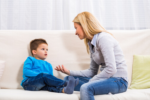 mãe sentada no sofá disciplinando seu filho