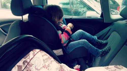 criança sentada em cadeirinha de carro com assento voltado para trás