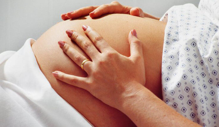 mãe com as mãos sobre a barriga