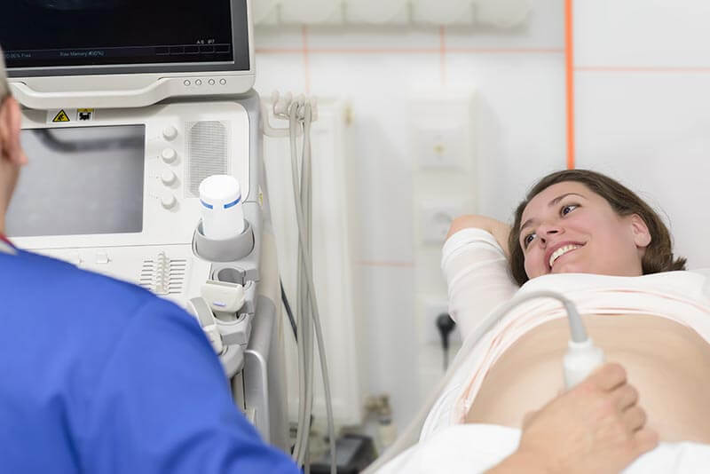 médico fazendo uma ultrassonografia em mulher grávida