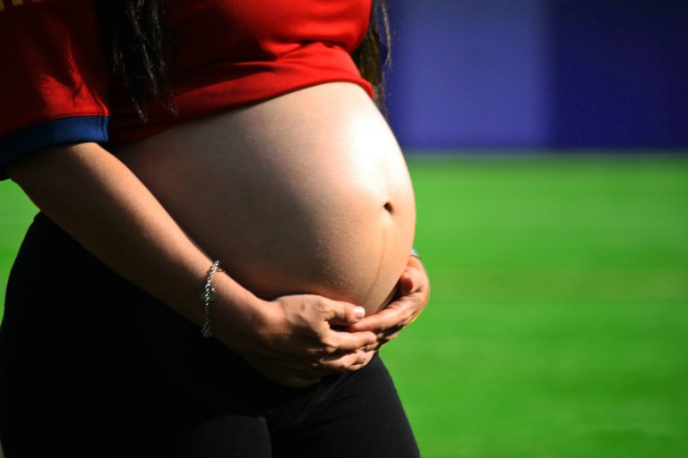 mulher grávida acariciando sua barriga