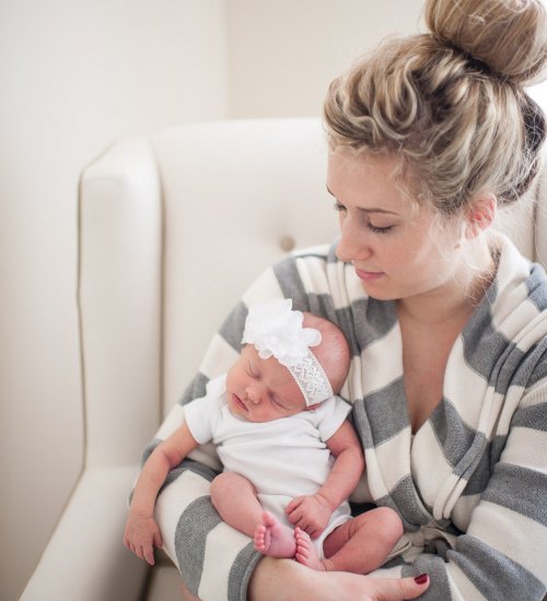 bebê dormindo no colo da mãe em posição inadequada