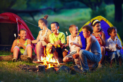 crianças ao redor de uma fogueira assando marshmallow e os ditados populares