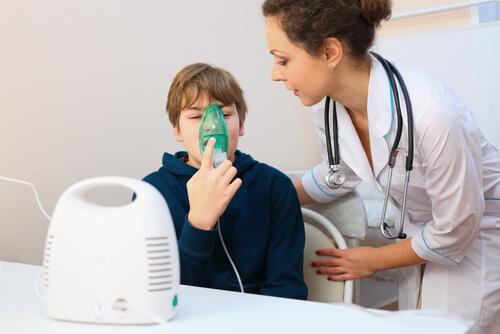 menino com nebulizador ao lado da pediatra, bronquite