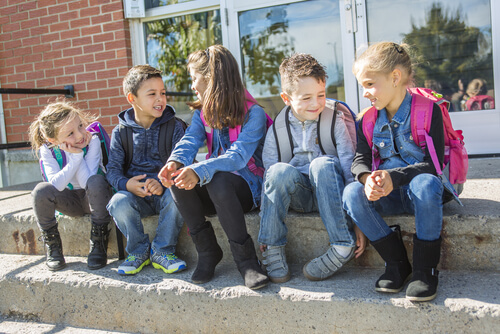crianças conversando no pátio da escola sobre os ditados populares