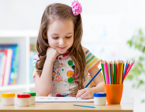 Destro ou canhoto, menina pintando com lápis de cor