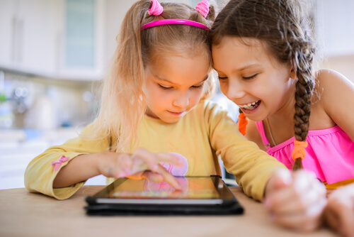 Duas crianças brincando com jogos eletrônicos