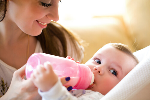 mãe dando leite na mamadeira para o bebe faz parte do aleitamento misto