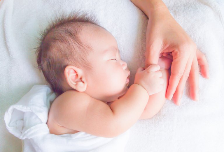 bebê dormindo segurando a mão da mãe não consegue dormir