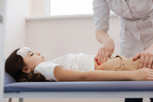 medica apalpando a barriga de uma menina doente, a apendicite em crianças