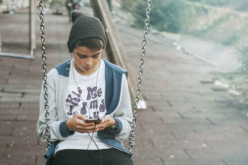 menino no celular, é importante proibir os smartphones para as crianças