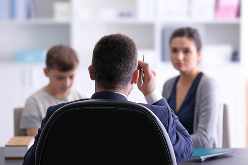 mãe e filho tendo reunião comprofessor