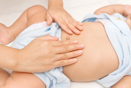 mãe acariciando a barriga do bebê com dor abdominal 