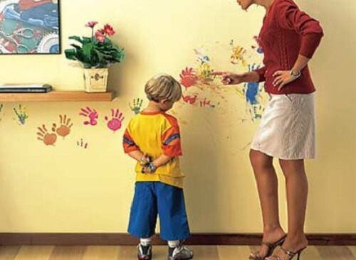 Mãe brigando com criança por sujar a parede