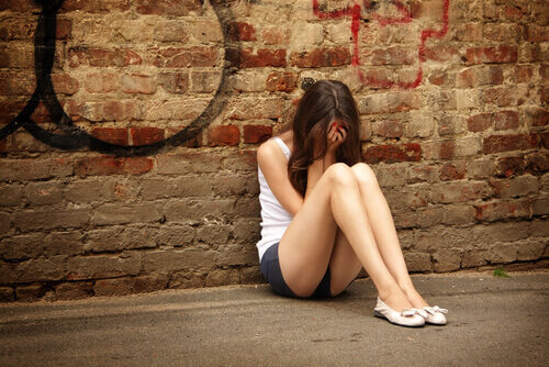 garota adolescente com depressão sentada no chão