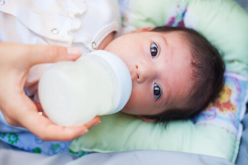 bebê bebendo leite na mamadeira