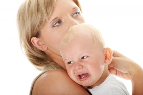 bebê chorando no colo da mãe