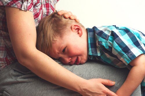 menino chorando no colo da mãe