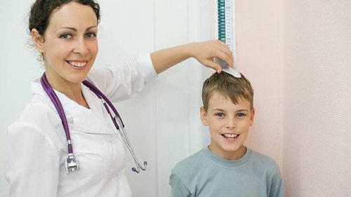 pediatra controlando a altura do menino