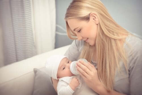 mãe dando mamadeira para bebê