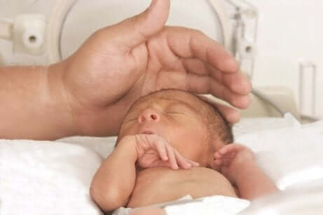 Pai cuidando do bebê prematuro na incubadora