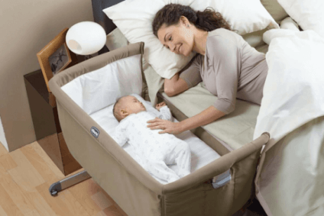 Mãe com seu filho deitado no colchão do bebê