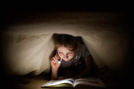 Menina lendo livro da coleção Abra e Descubra
