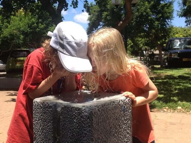 Crianças bebendo água numa tarde de verão