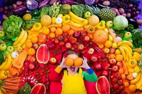 Mitos sobre as frutas: menina ao redor de várias frutas