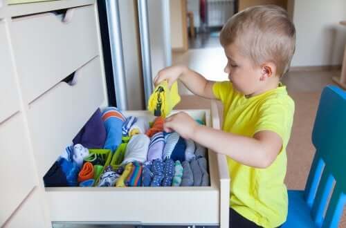 A promoção da autonomia na infância: menino guardando suas roupas