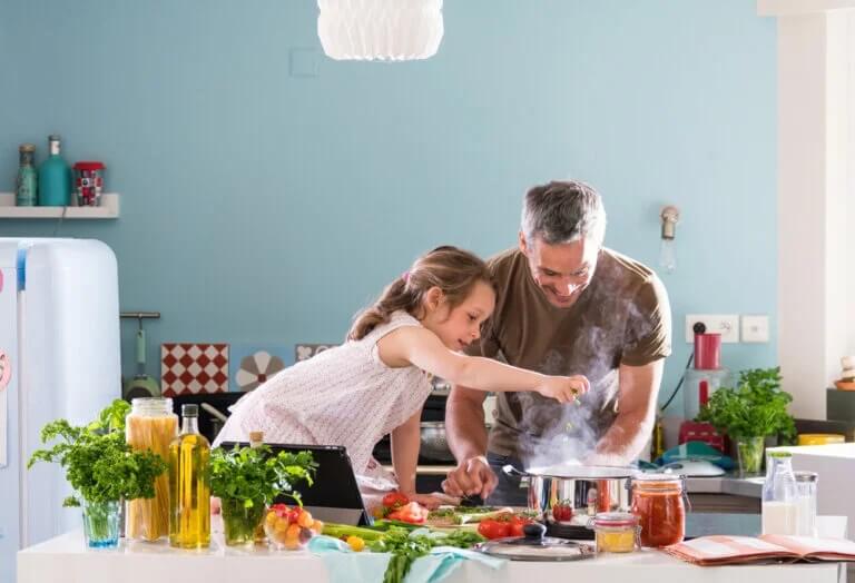 Pai e filha cozinhando em casa