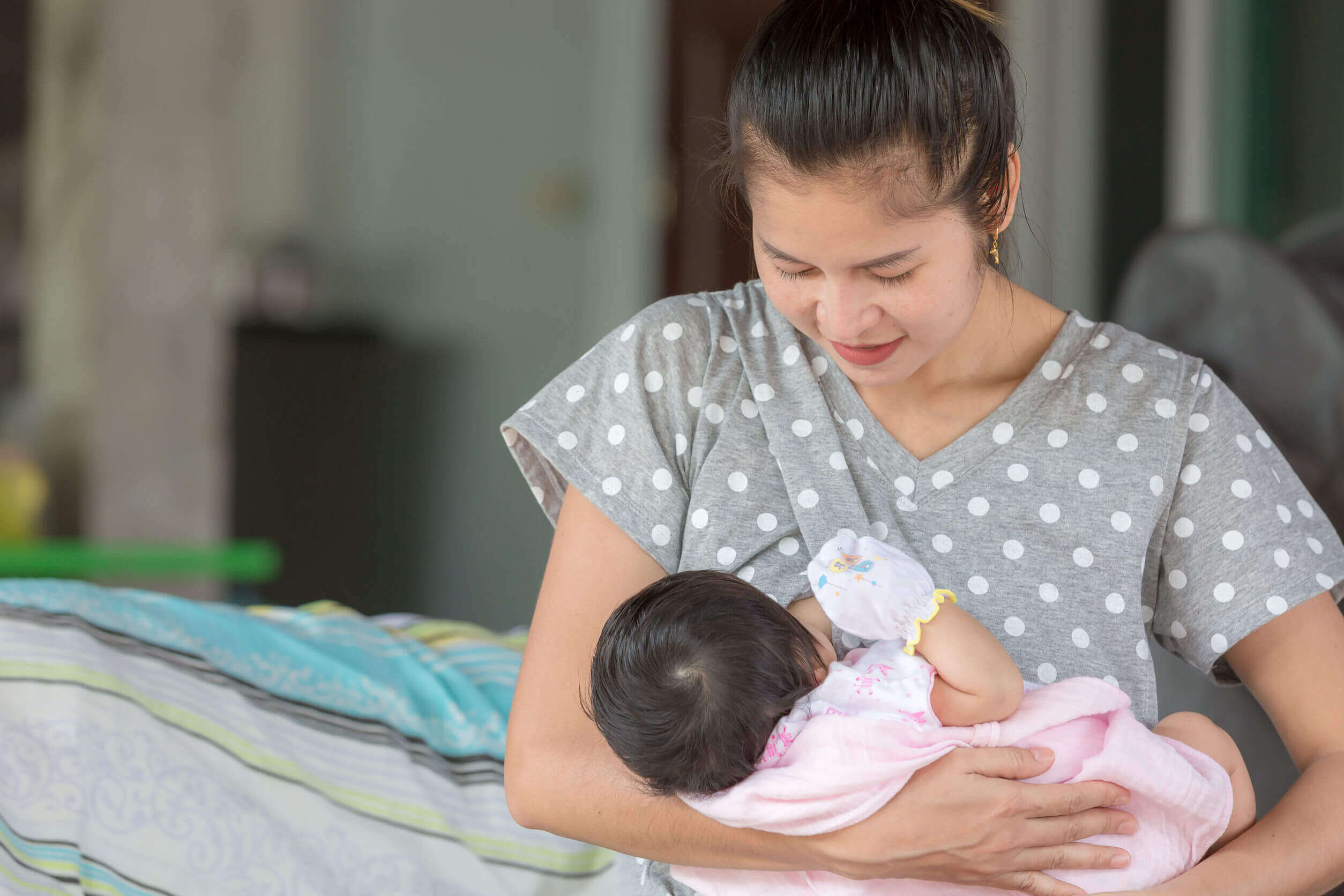 Mãe amamentando seu bebê com protetores de mamilo.