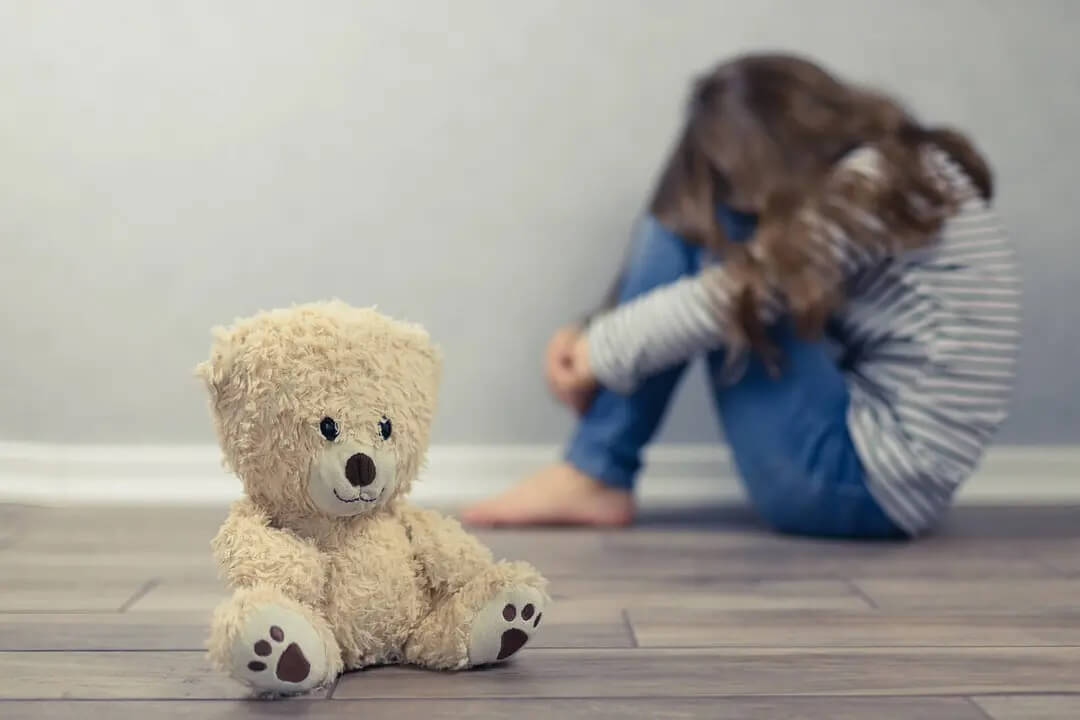 Menina muito triste com um ursinho de pelúcia enquanto pensava em suicídio.