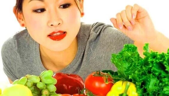 Mulher escolhendo entre frutas e verduras.